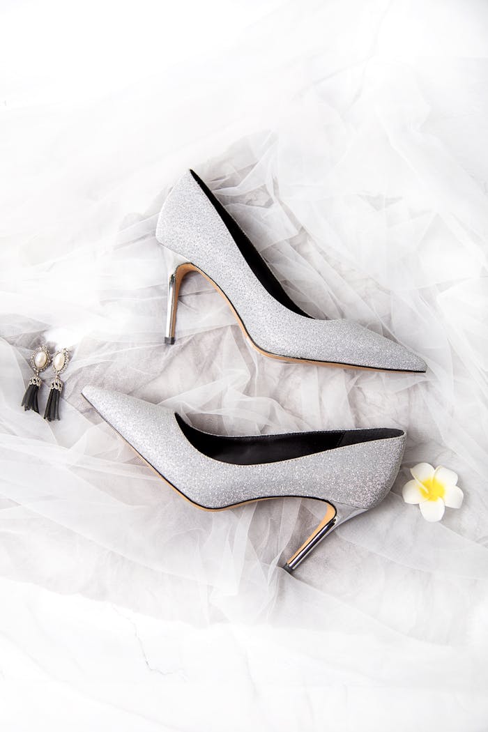 Chic and stylish silver high heels paired with elegant earrings, perfect for formal wear.